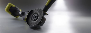 Gri arka planda kablosuz zımpara makinesi, yakın plan. Elektrikli elektrikli aletler. DIY onarımı, inşaat ekipmanları
