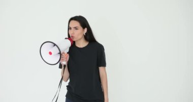 Kızgın kadın, hoparlörden gri arka planda öfkeyle bağırıyor. Esmer kadın, memnuniyetsizliği yansıtan yükseltilmiş ses yoluyla öfkesini serbest bırakıyor.