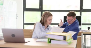 İş arkadaşları şirket ofisindeki işyerindeki mali raporları tartışıyor. Erkek, bir kadınla yaptığı anlaşmanın doğruluğunu kanıtlıyor.