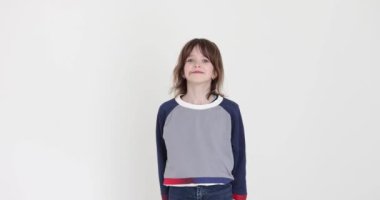 Benli liseli kız beyaz arka plana karşı olduğunu belirtiyor. Hoş gülüşlü itaatkar çocuk stüdyoda anlaşma jesti yapıyor.