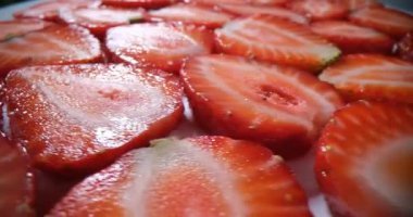 Olgun çilek dilimleri lezzetli pastayı süslüyor. Tatlı çilek tabakası yaz tatlısının üstüne yumuşak krema ile kafe tabağında döner.