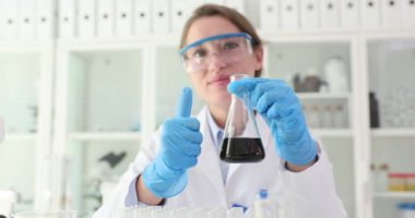 Kadın araştırmacılar, siyah sıvı ham petrolle dolu bir matara tuttuklarını gösteriyor. Bilim adamı sonuçlardan ve başarılı tamamlamadan memnun olduğunu belirtti