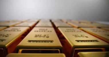 Pırıl pırıl yüzeyi olan altın külçeler kusursuz düz sıralarda yatar. Altın külçelerinin titiz düzenlenmesi değerli metalin değerini vurguluyor