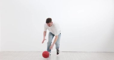 Adam ışık odasında top sürmeyi öğreniyor. Spor sakallı erkek egzersizleri koridorda yavaş çekimde. Atletik hobi ve eğlence