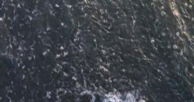 SAVAŞ harfleri plajın ıslak kumlarına dikkatlice yazılmış. Dalgalar kıyıya vurarak yazıtları silmeye çalışıyor. Deniz kelimelerin harflerini siler