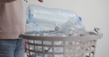 Kadın şişeyi plastik yavaş çekimle geri dönüşümlü kutuya atıyor. Bilinçli kadın atık ayıklama çevre koruma ve kirliliği azaltma