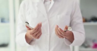 Kadın dişçi, diş fırçasının gerekli diş aletlerinin yanında olduğunu gösteriyor. Kadın hastaya etkili ağız temizliği ve önleyici diş muayenelerinin faydaları hakkında eğitim veriyor.