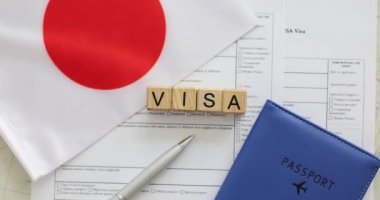 Tahta küplere kelime vizesi, Japonya bayrağı ve doldurulmuş başvuru formuna pasaport. Yabancı ülke kavramını ziyaret etmek için resmi izin