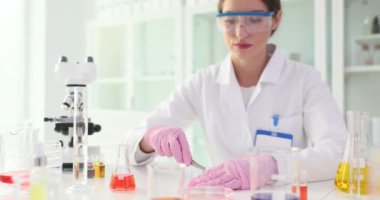 Biyolog kadın, laboratuvarda parmak izleri gösteren cımbızla örnek aldı. Kimya laboratuarındaki test sonuçlarından memnun kadın asistan