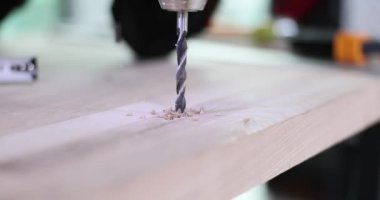 Yavaş çekimle tahta tahtada delik açma işlemi. Yenileme ve mobilya yapımı için özel bir araç gerekli