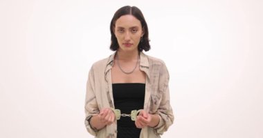 Beyaz arka planda kelepçeleri olan çaresiz genç bir kadın. Bayan, özgürlük kısıtlamalarıyla olumsuz duygular yaşıyor. Duygusal kargaşa.