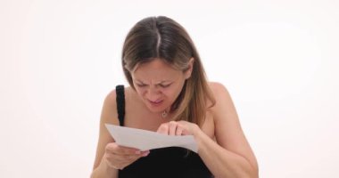 Vizyon sorunu olan bir iş kadını beyaz arka planla ilgili gazeteleri okur. Kadın girişimci gözlüksüz belgenin metnini tanımaya çalışıyor