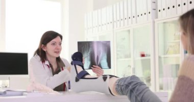 Travmatolog hastanın ayaklarının röntgenini ve klinikteki ağır çekimde gösteriyor. Doktor kadın hastanede yaralarını iyileştiriyor.