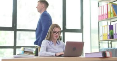 Erkek patron, ofisteki dizüstü bilgisayarda yazan kadın sekretere belge mesajı yazdırıyor. Şirket yöneticisi ve katip önemli bir müşteriye e- posta yazar