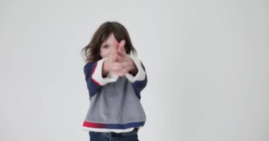 Sevimli küçük kız elini kaldırır ve beyaz arka planda silah sesi taklidi yapar. Doğum lekesi olan iyimser çocuk mutluluk ve kaygısız enerji yayıyor.