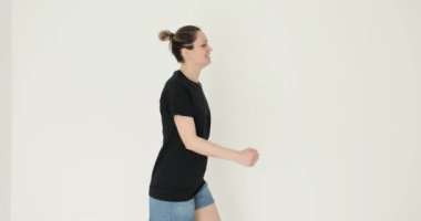 Atletik kadın yerinde enerjik bir şekilde koşuyor. Kadın uygulamaları günlük fiziksel aktivitenin önemini gösteren günlük rutinlere dahil eder.