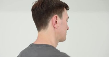 Stüdyoda beyaz arka planda dönen şık erkek modeller. Adam berber dükkanında ağır çekimde yürürken modern saç stili gösteriyor.