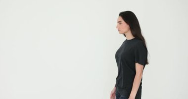 Kendine güveni tam bir kadın moda stüdyosu boyunca yürüyor. Genç esmer kadın model, beyaz arka planda poz veren gösterinin bir bölümünü prova ediyor.
