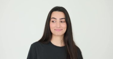 Uzun siyah saçlı oyuncu kadın beyaz arka planda flört ediyor. Flört eden yüz ifadesi olan güzel bir bayan. Dişi model taklit eder