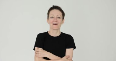 Kadın beyaz arka planda yüz taklidi yaparak güçlü bir şok yaşıyor. Kadın sürpriz bir olaydan sonra ağzını kapatmak için alt çenesini kaldırır.