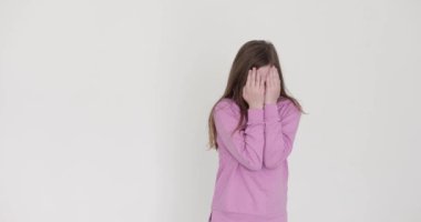 Gevşek saçlı kız, ağlama taklidi yapmak için gözlerini yumruklarıyla ovar. Çocuk, hareketli hareketlerle oyalanıyor.