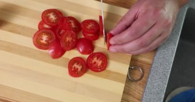 Aşçı tarafından işletilen keskin bıçak domatesi düzgün daireler çizer. Paslanmaz çelik mutfak aletlerinin kalitesinin gösterimi yavaş çekimde