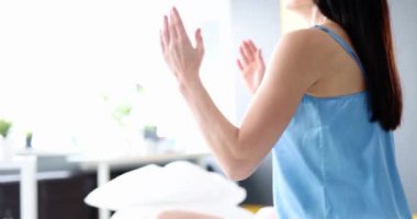 Woman sitting in bed after morning yoga. Focus on healthy object of headache and toning body. Concept of sports activity and meditation.