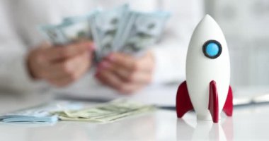 İş adamları roketin yanında para sayar. İş ve mali kazanç kavramında hızlı başlangıç