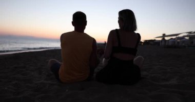 Aşık bir adam ve bir kadın plajda sarılıyorlar. Çocuk koşup onlara sarılıyor. Aile tatili aşk ve seyahat