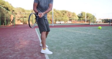 Genç adam kortta tenis topuna vuruyor. Tenis oynamak ve antrenman yapmak