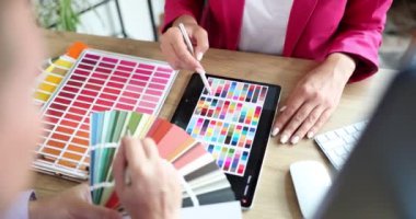 Renk paleti ve şablonla çalışan iç mimar arkadaşlara yakın plan. Web sitesi başlık tasarımı için ortak tartışma afişi planlayan tasarımcı ve istemci yaratıcı kavram