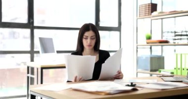 Ofiste bir sürü belgesi olan yorgun bir bayan yönetici. Fazla mesai yorgunluğu işteki kötü ruh hali.