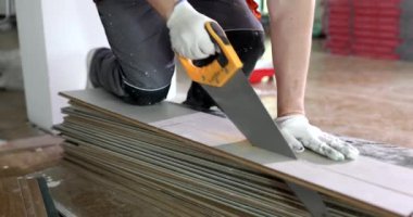 Testere testereli marangoz lamine çarşaf kesiyor ve döşemeleri yeniletiyor. Döşeme döşemesi