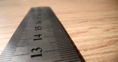 Masanın üzerinde milimetre cinsinden metal yapı cetveli var. Ölçüm ve ölçüm