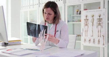 Bilek iskeletlerinin röntgenini tutan ve hastada kemik ağrısını teşhis eden bir doktor. Hastanede kemiklerin ve eklemlerin durumunun profesyonel incelemesi