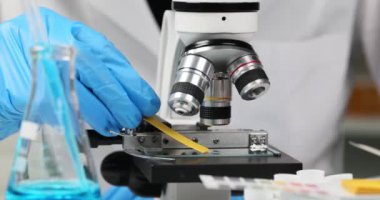 Laboratuvardaki kimyager ph şeritlerini mikroskopta kontrol ediyor. Zehirli asidik sıvıların keşfi