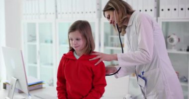 Pediyatrist steteskoplu bir kızın ciğerlerini dinler. Çocuklarda bronşit