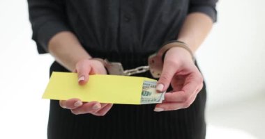 Elleri kelepçeli kadın, elinde dolarlarla zarf tutuyor. Seo rüşvet ve yolsuzluktan tutuklandı