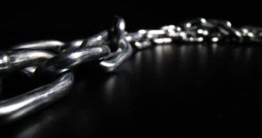 Siyah arka planda gümüş metal zincir. Kısa bağlantıları olan düz metal zincir.
