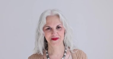 Kameraya bakan gülümseyen yaşlı kadın portresi. Kırışıklıkları olan yaşlı kadının neşeli duyguları.