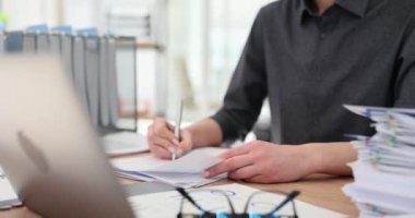 Müdür, mali belgeleri istatistiklerle okur, düzeltmeler yapar ve verileri karşılaştırır. Makaleyi değiştirmek için özenli bir kadın.