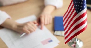 Vize başvuru formu ve Amerikan bayrağında kalem tutan kişi. ABD 'ye göç