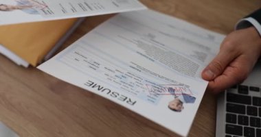 Erkek patronun elleri, onaylanmış özgeçmişi ellerinde tutuyor. Mükemmel özgeçmiş ve işe alım