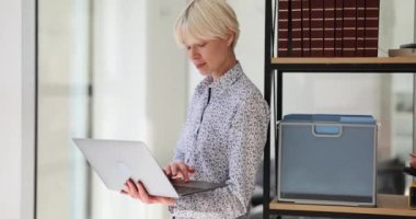Konsantre sarışın kadın internet sitesine özgeçmişini dizüstü bilgisayarında yazıyor. Genç ofis müdürü teknoloji bilgisi ile yeni bir iş başvurusunda bulundu