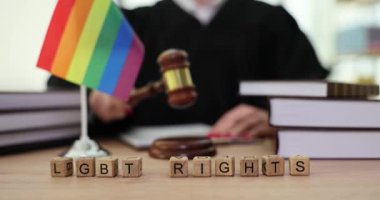 Tahta küplerden yapılmış LGBT hakları, tokmakla vuran kadın hakime karşı. Mahkeme oturumunda gökkuşağı bayrağıyla hakim karşısına çıkacak.