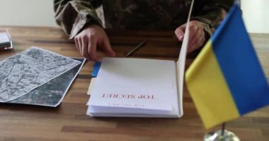 Askeri çalışmalar, iş yerindeki masada karşı saldırı ile ilgili gizli belgeler. Bölgenin uydu görüntüleri ve Ukrayna bayrağı yakınındaki erkek şahıs yavaş çekim