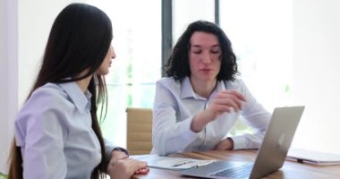 Erkek çalışanlar, ofiste masada oturan kadın stajyere iş prensiplerini açıklar. Genç adam ve kadın ortak proje üzerinde çalışan iş meselelerini tartıştılar