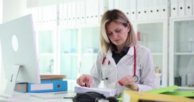 Kadın sıhhiyeci hasta veri depolama için klasöre kağıt belgeler yerleştiriyor. İş yerindeki uzmanların iş akışı ve sıralama kavramı. Tıp mesleği