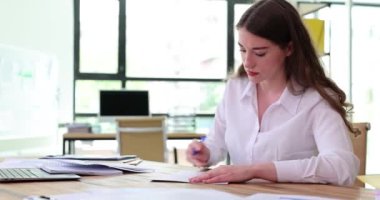 Üretken bir iş kadını, ofis ahşap masasında otururken hemen gerekli tüm belgeleri imzalar. Bayan işveren önemli sözleşmelerle çalışır. Yoğun zamanlama