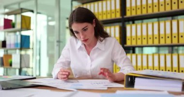 Sinirli işçi gergin bir şekilde masadan yumruklarla ve nefret edilen analitik kağıtlarla vuruyor. İş kadını, girişim satışlarındaki düşüşten bıktı